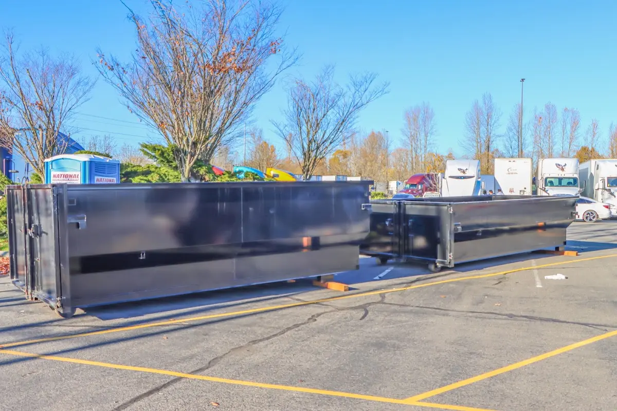 Professional dumpster rental service with roll-off container on residential driveway in Layton